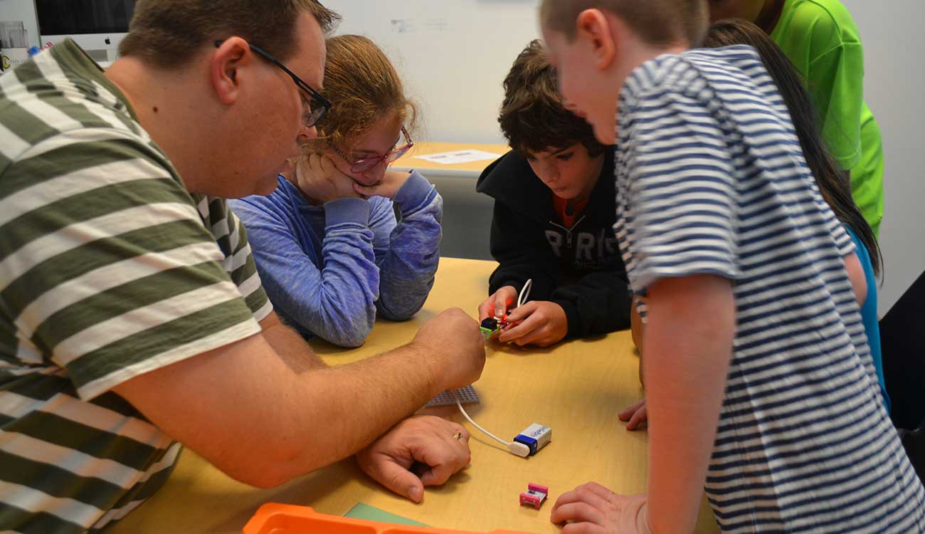 Man helping students with science experiment, Robin Andrews